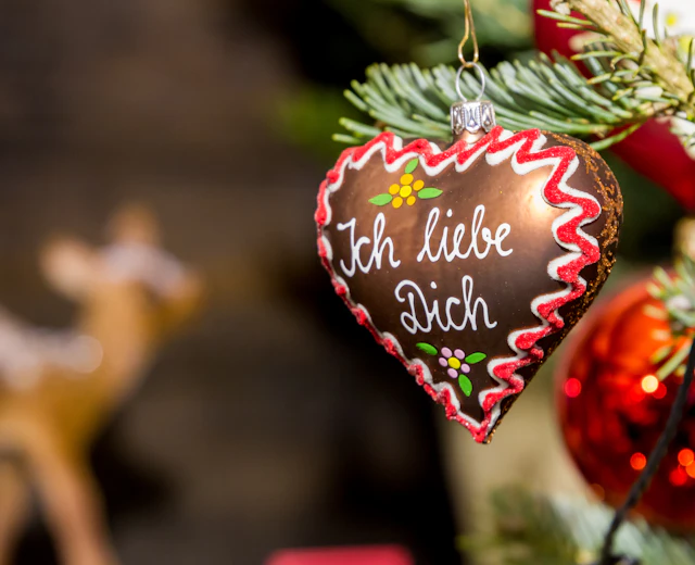 Traditionelt tysk julemarked hjerteornament med kærlighedsbesked hængende på juletræ