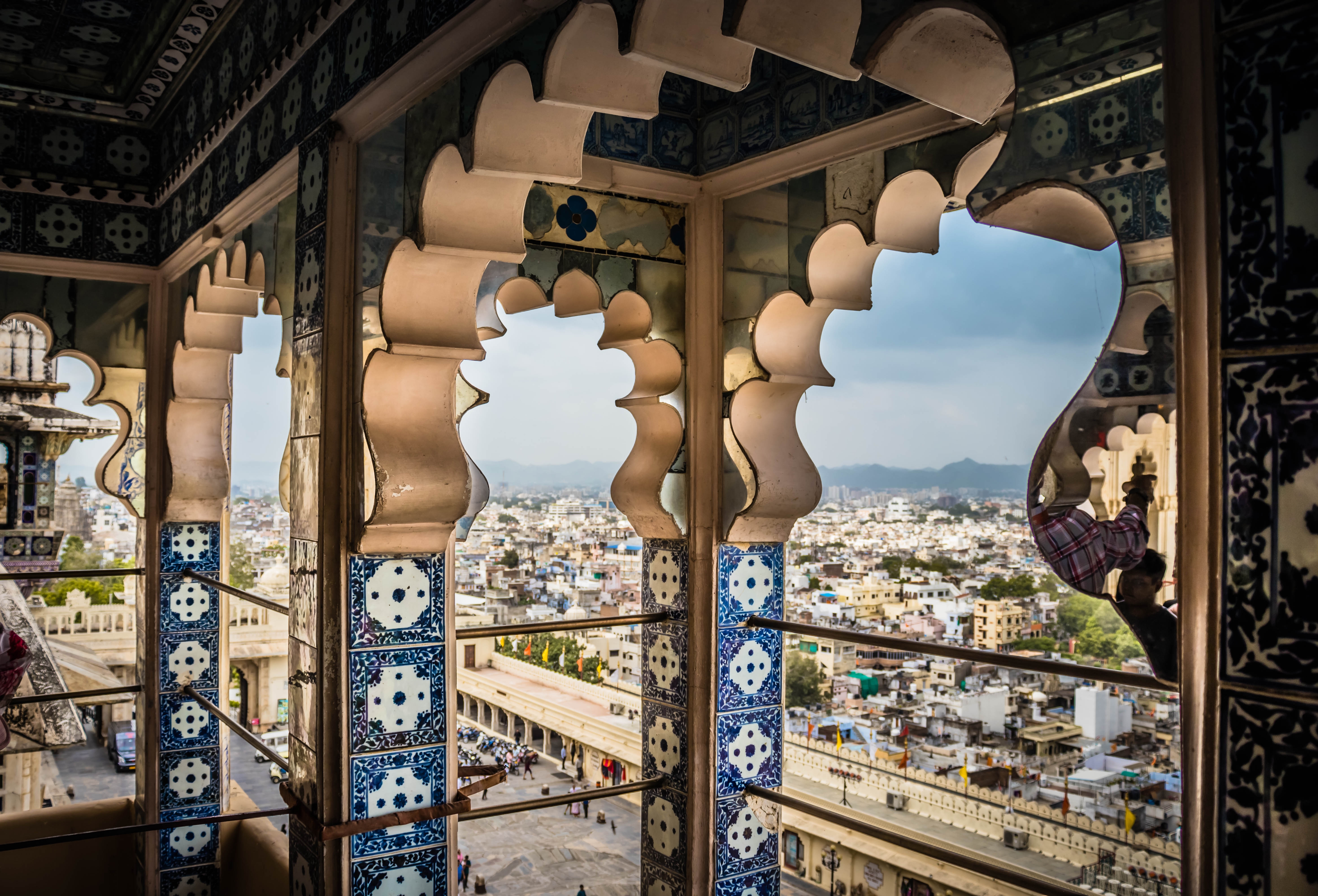 Imponerende udsigt over det majestætiske City Palace i Udaipur med dets hvide facader, kupler og buer, der spejler sig i Lake Pichola