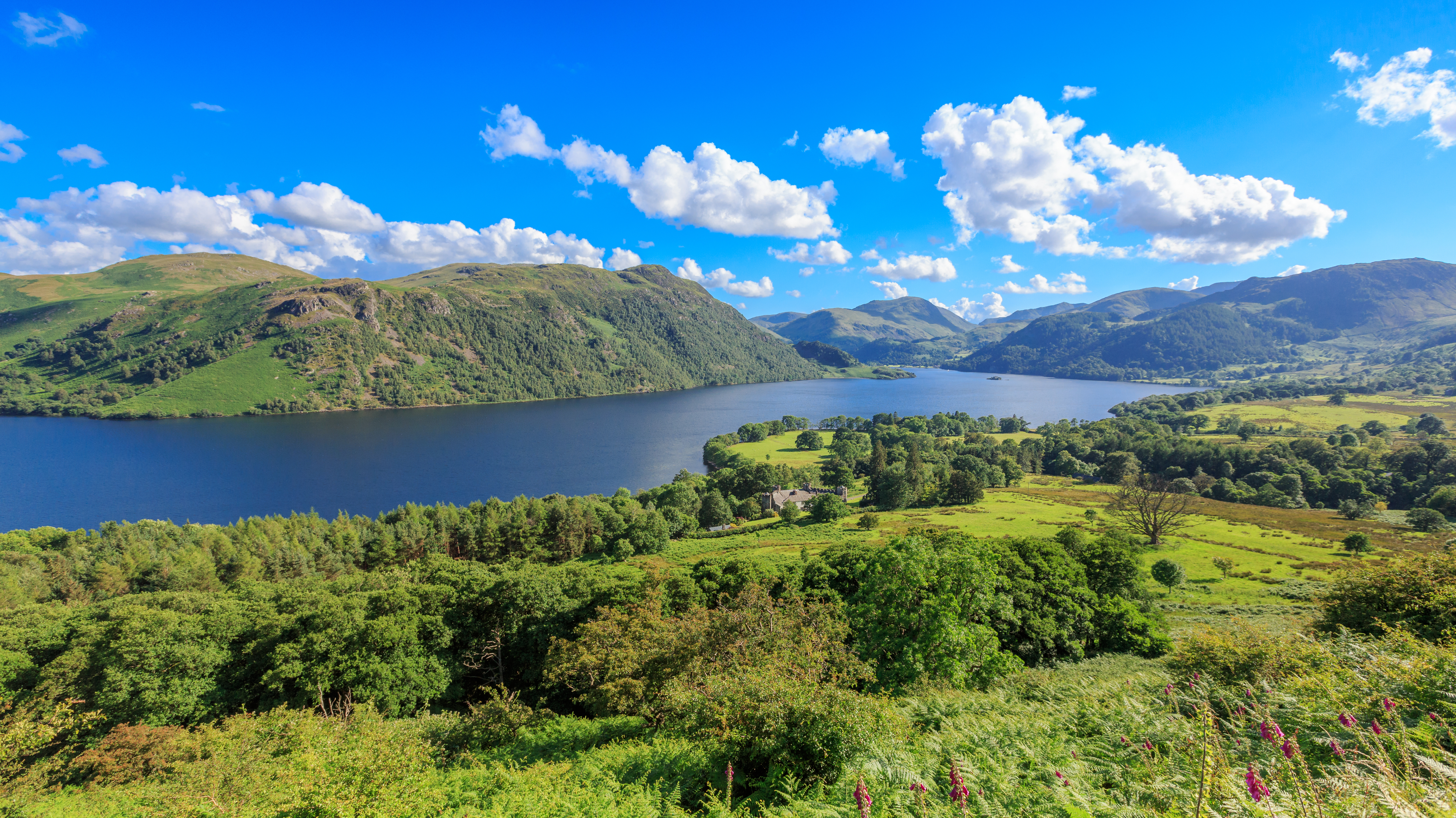 Luftfoto af Ullswater sø i Lake District England med grønne bakker og blå himmel