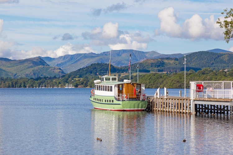 Idyllisk udsigt over Ullswater-søen fra molen ved Pooley Bridge med traditionel dampbåd i Lake District Nationalpark, England