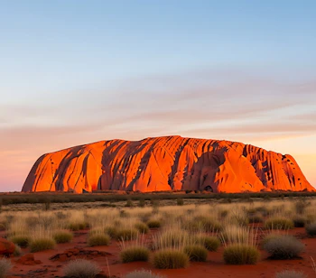 Uluru ved solopgang med den karakteristiske røde sandsten, der lyser op i det australske outback