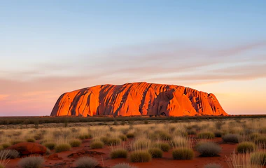 Uluru ved solopgang med den karakteristiske røde sandsten, der lyser op i det australske outback