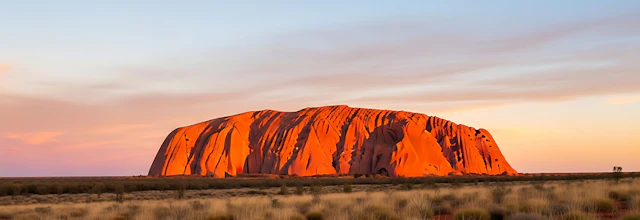 Uluru ved solopgang med den karakteristiske røde sandsten, der lyser op i det australske outback