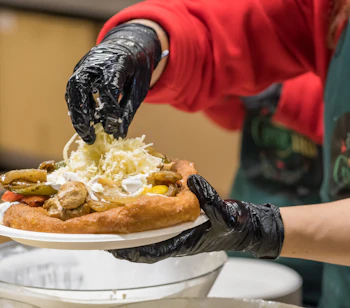 Traditionel ungarsk langos med kød, ost og grillede grøntsager serveret på Budapests julemarked, en populær lokal gadespecialitet