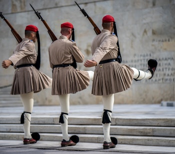 Traditionelt vagtskifte med Evzones-soldater i farverige uniformer ved parlamentet på Syntagma-pladsen i Athen, Grækenland