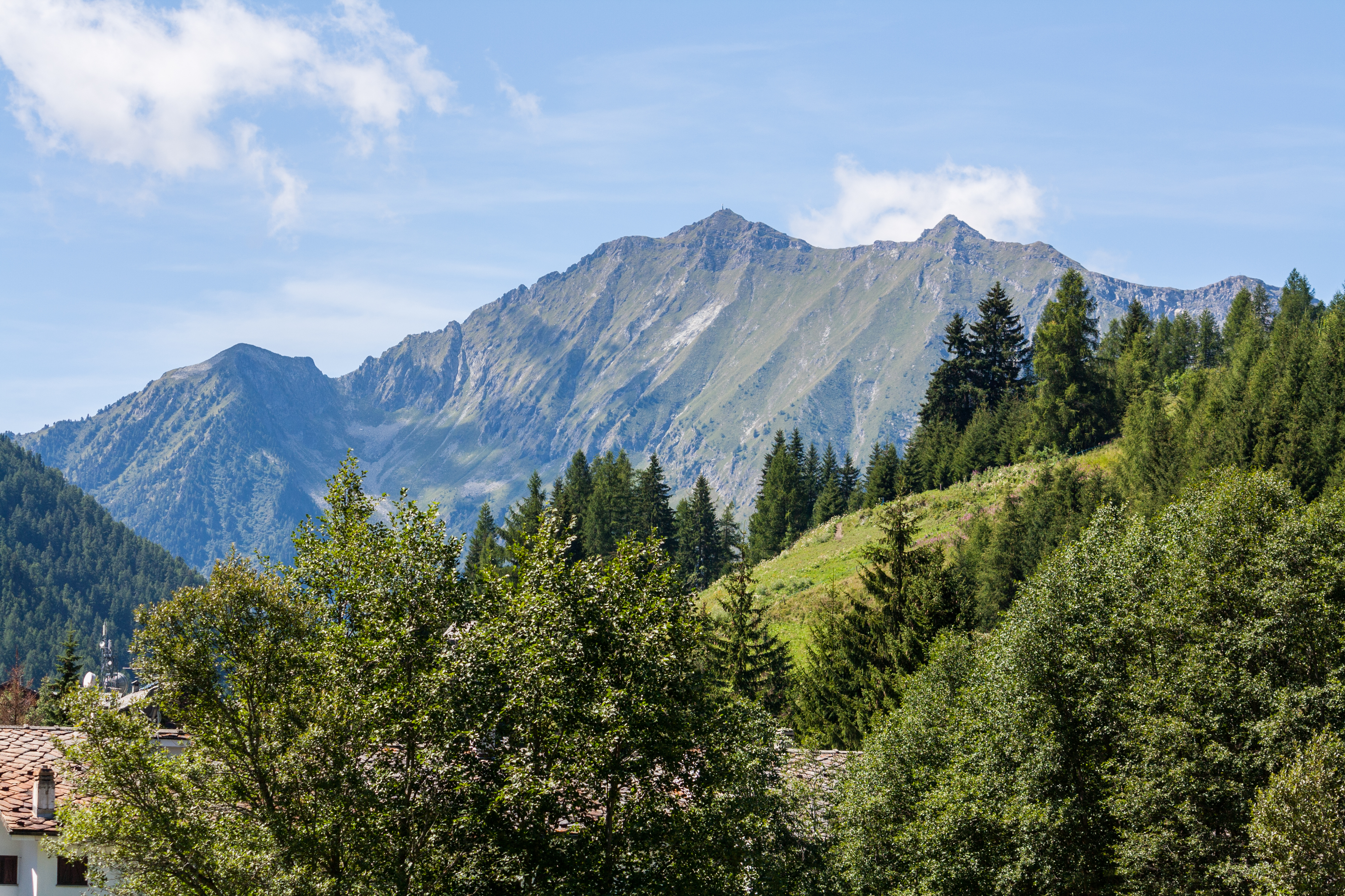 Idyllisk sommerlandskab i Val d'Ayas dalen med traditionelle Walser stenhuse og grønne enge under Monte Rosa bjergene i Aosta, Norditalien