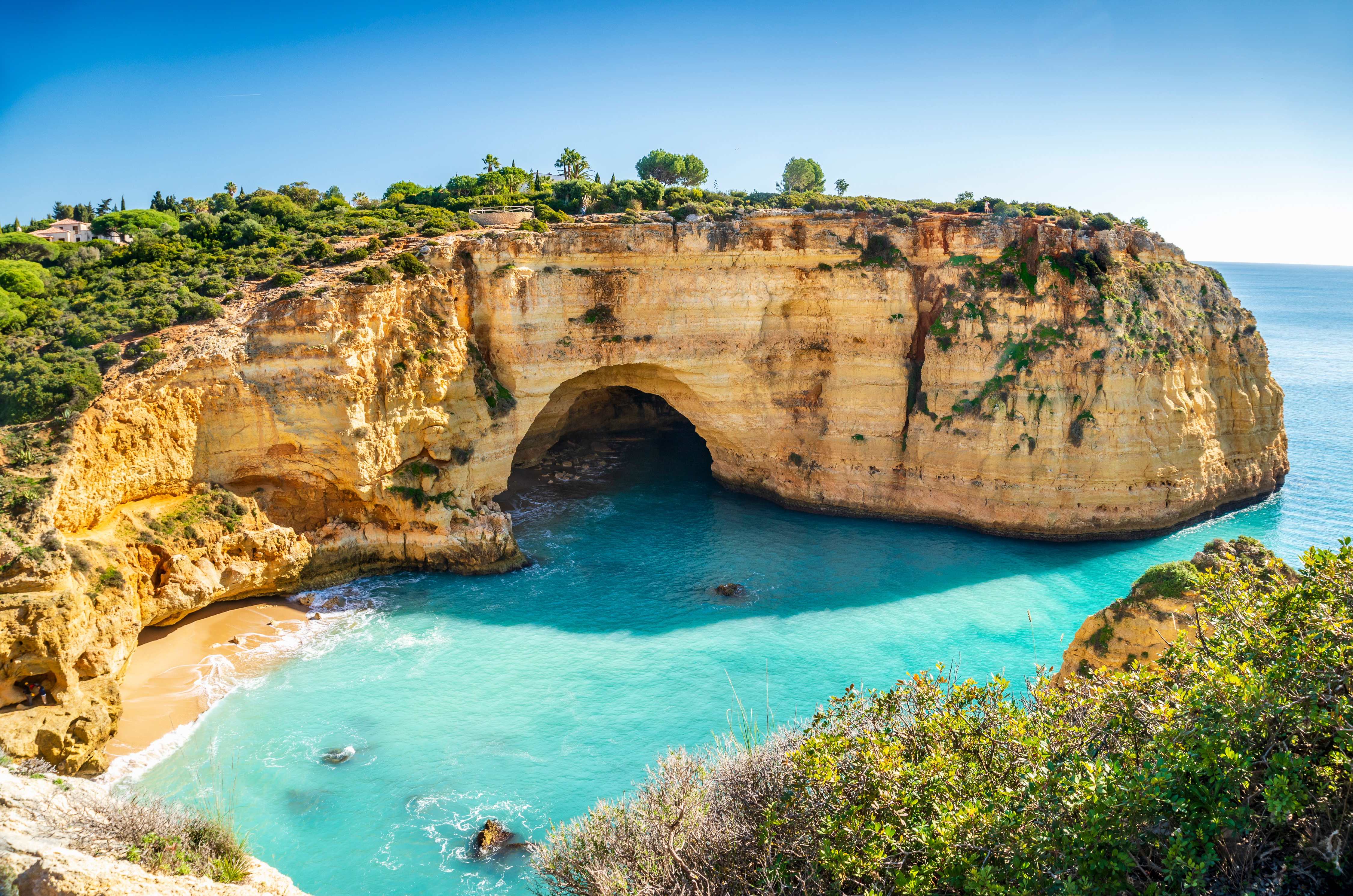 Smuk udsigt over Vale Covo stranden med turkisblåt vand og gyldne sandstensklipper i Algarve, Portugal