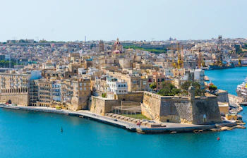 Betagende panoramaudsigt over Valletta fra Middelhavet med Maltas hovedstads gyldne sandstensbygninger og historiske fæstningsværker