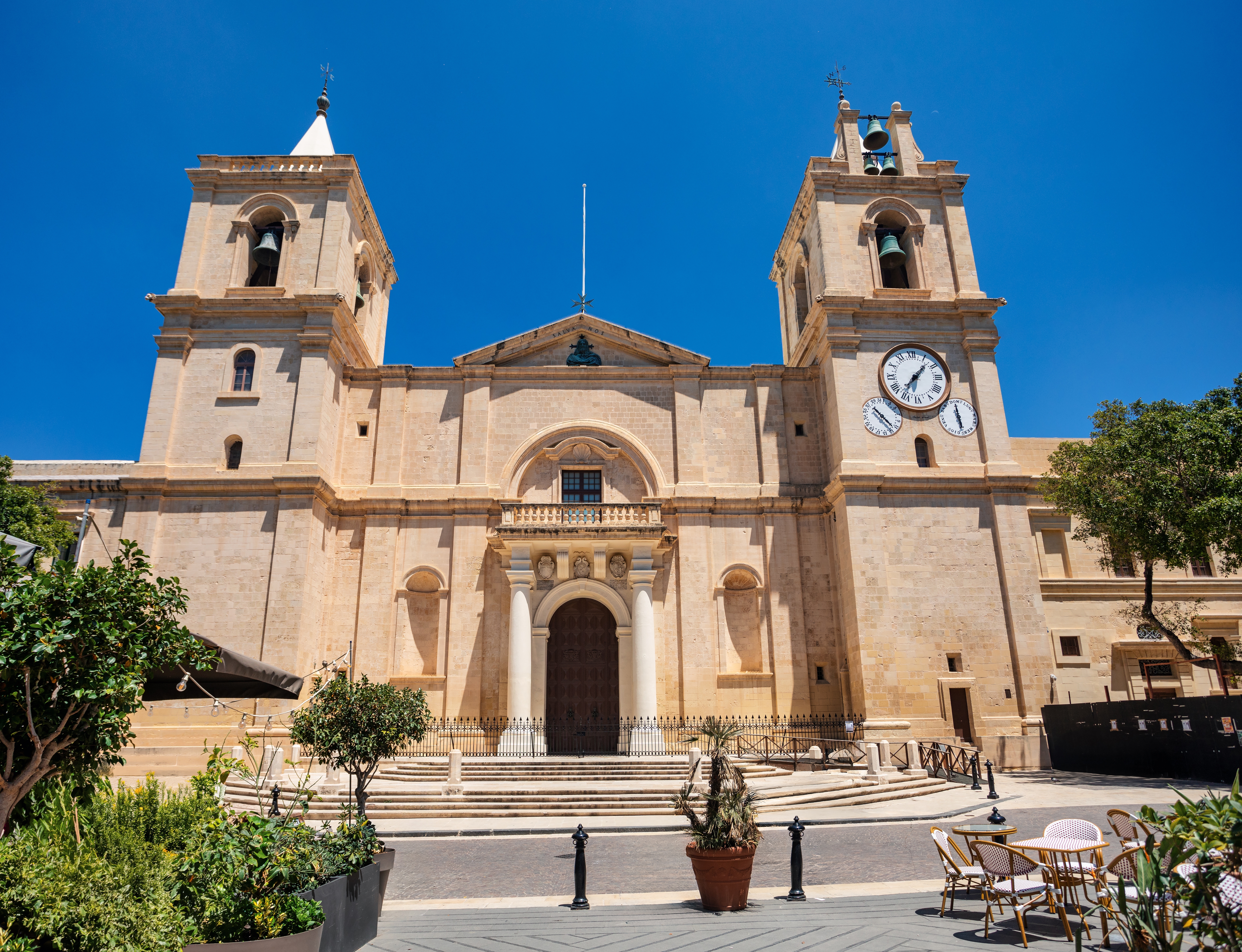 Den imponerende barokfacade af St. John's Co-Cathedral i Valletta, Malta, med dens detaljerede stenudskæringer, monumentale indgangstrappe og historiske arkitektur