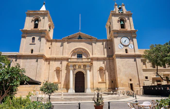 Den imponerende barokfacade af St. John's Co-Cathedral i Valletta, Malta, med dens detaljerede stenudskæringer, monumentale indgangstrappe og historiske arkitektur