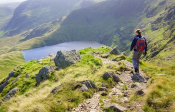 Kvindelig vandrer på bjergstien Long Stile med udsigt over Blea Water i Lake District, England