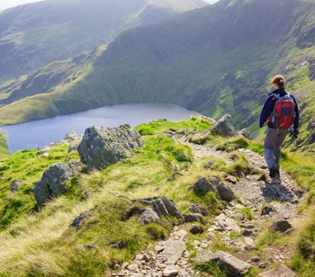 Kvindelig vandrer på bjergstien Long Stile med udsigt over Blea Water i Lake District, England