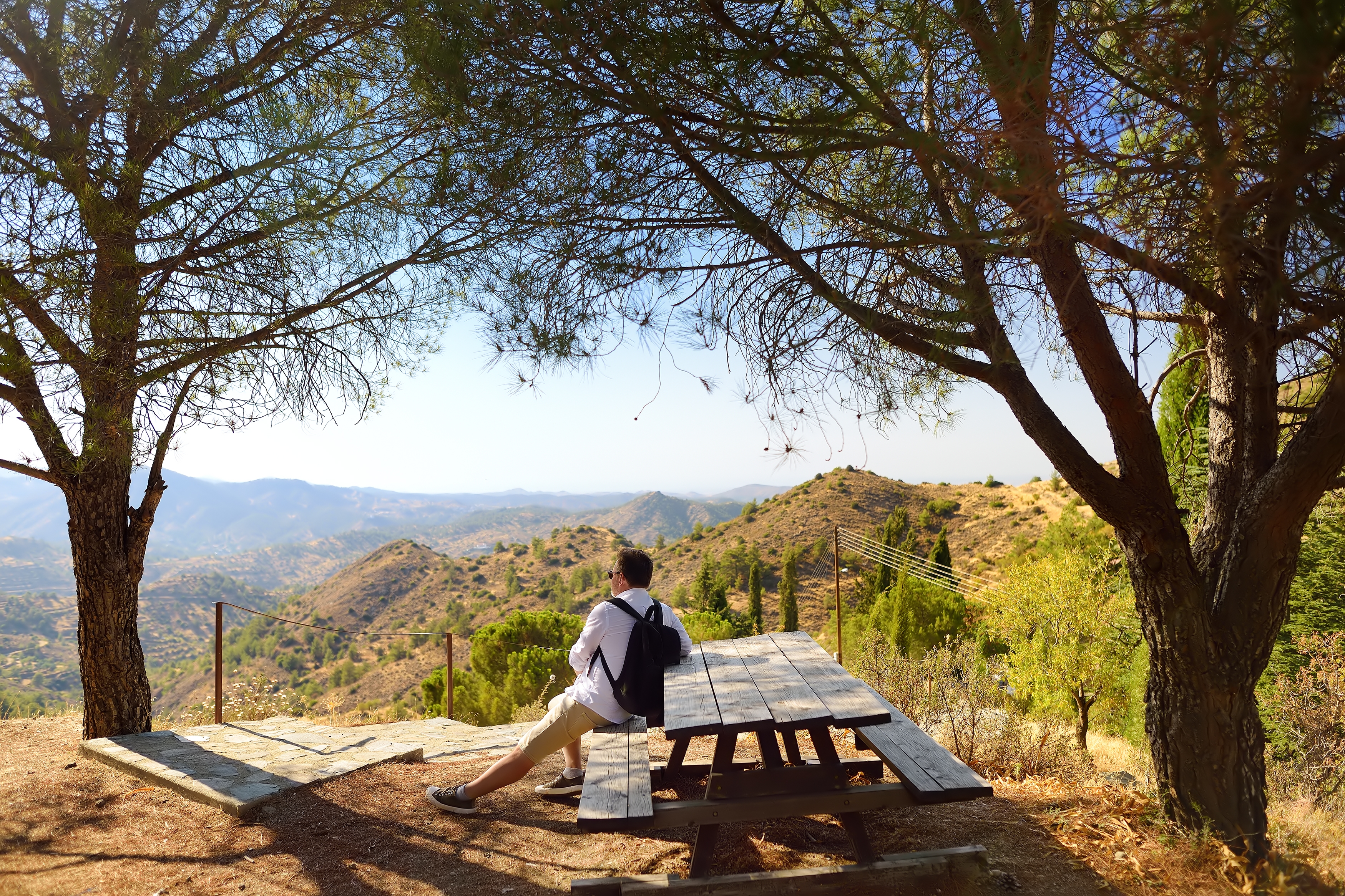 Moden mand nyder udsigten over Troodos-bjergenes nationalpark på Cypern under en solrig vandretur om sommeren