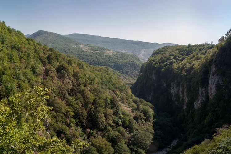 Spektakulær vandresti med rækværk højt over Okatse-kløften i Georgien med udsigt over Svanetis bjerglandskab