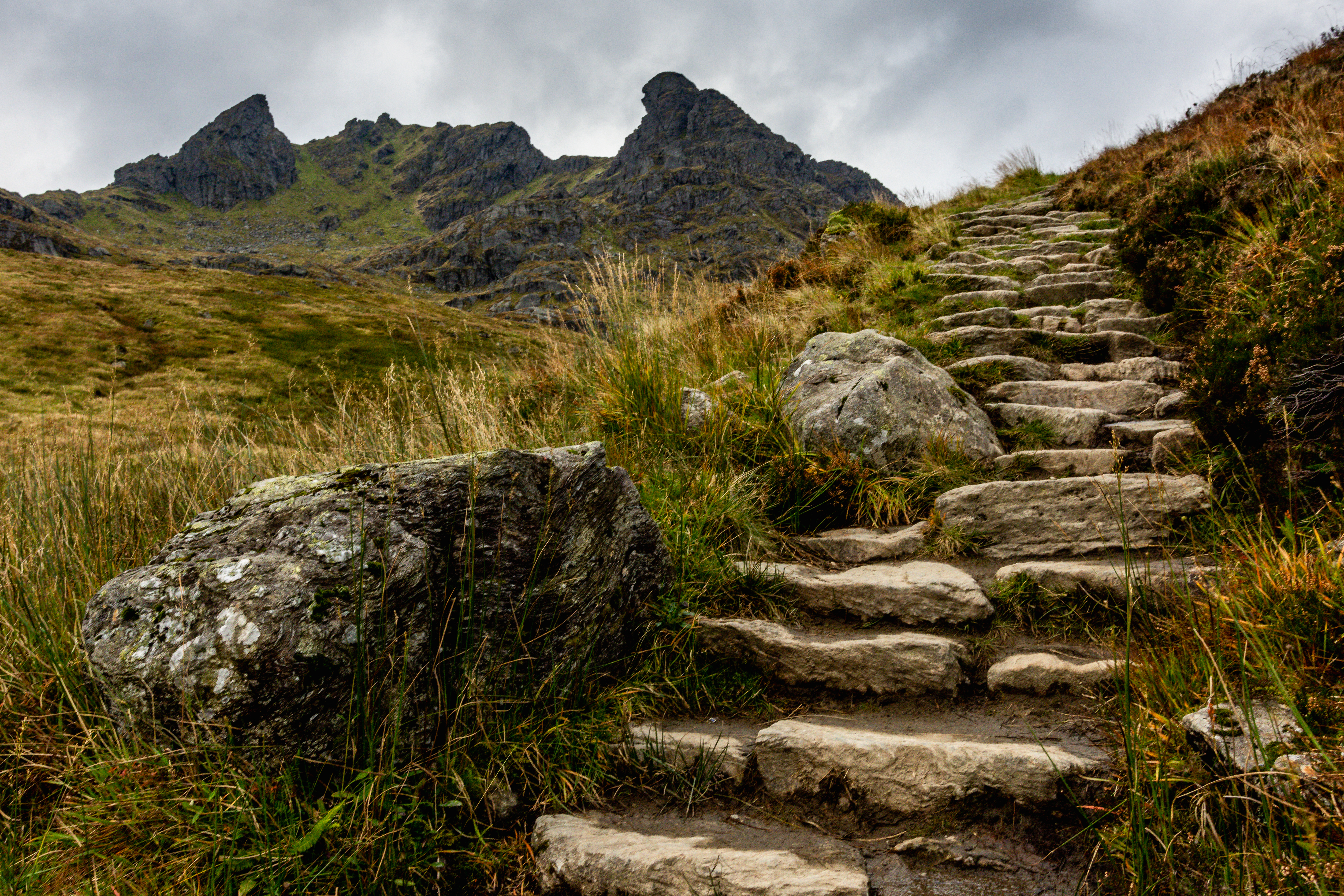 Naturskøn vandresti på vej mod The Cobbler toppen i det skotske højland med dramatisk bjerglandskab og skyer