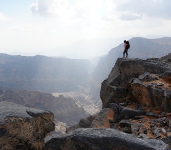 Eventyrlig vandring ved Jebel Shams i Oman med en person der nyder den storslåede udsigt over canyon landskabet