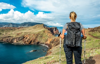 Kvinde vandrer langs de dramatiske klippeskrænter ved Ponta de Sao Lourenco på Madeira med udsigt over Atlanterhavet