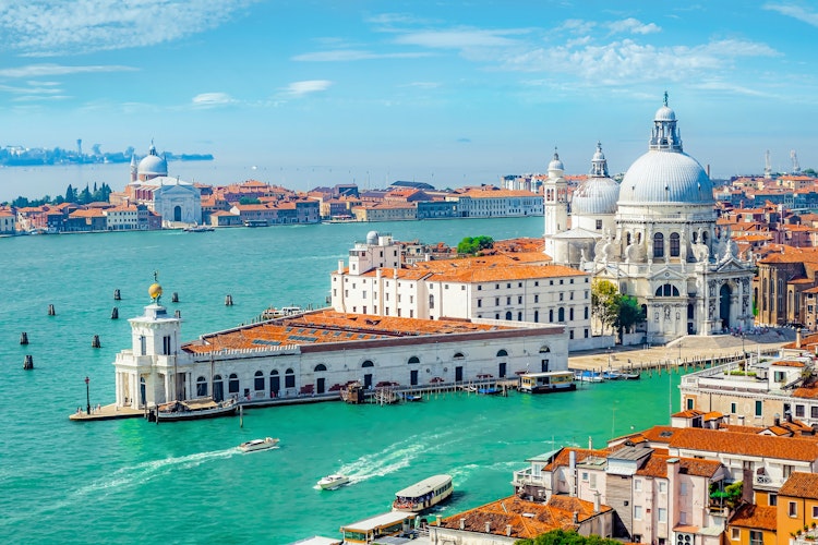 Smuk udsigt over Santa Maria della Salute katedralen i Venedig med den ikoniske kuppel der troner over Grand Canal og den blå venetianske lagune