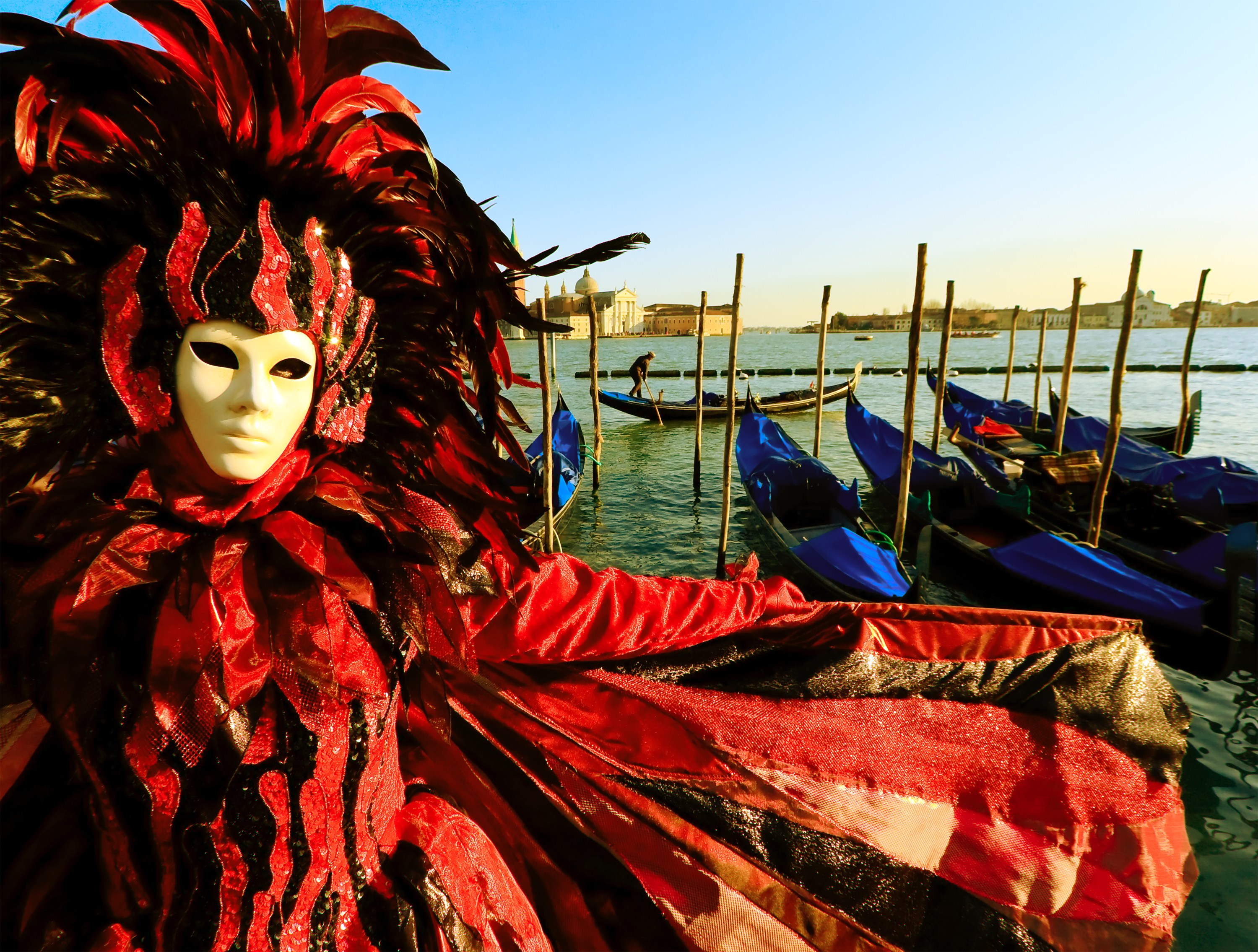Person i traditionel venetiansk karnevalsdragt med guldmaske på Piazza San Marco under Venedigs berømte karneval i Italien