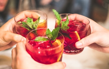 Glade venner der skåler med sangria på en hyggelig spansk restaurant under langtidsferie i Andalusien