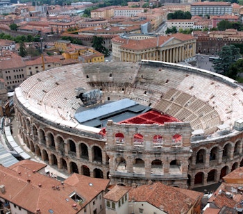 Luftfoto af Veronas historiske centrum med det antikke romerske amfiteater Arena di Verona omgivet af røde tegltage i Veneto, Italien