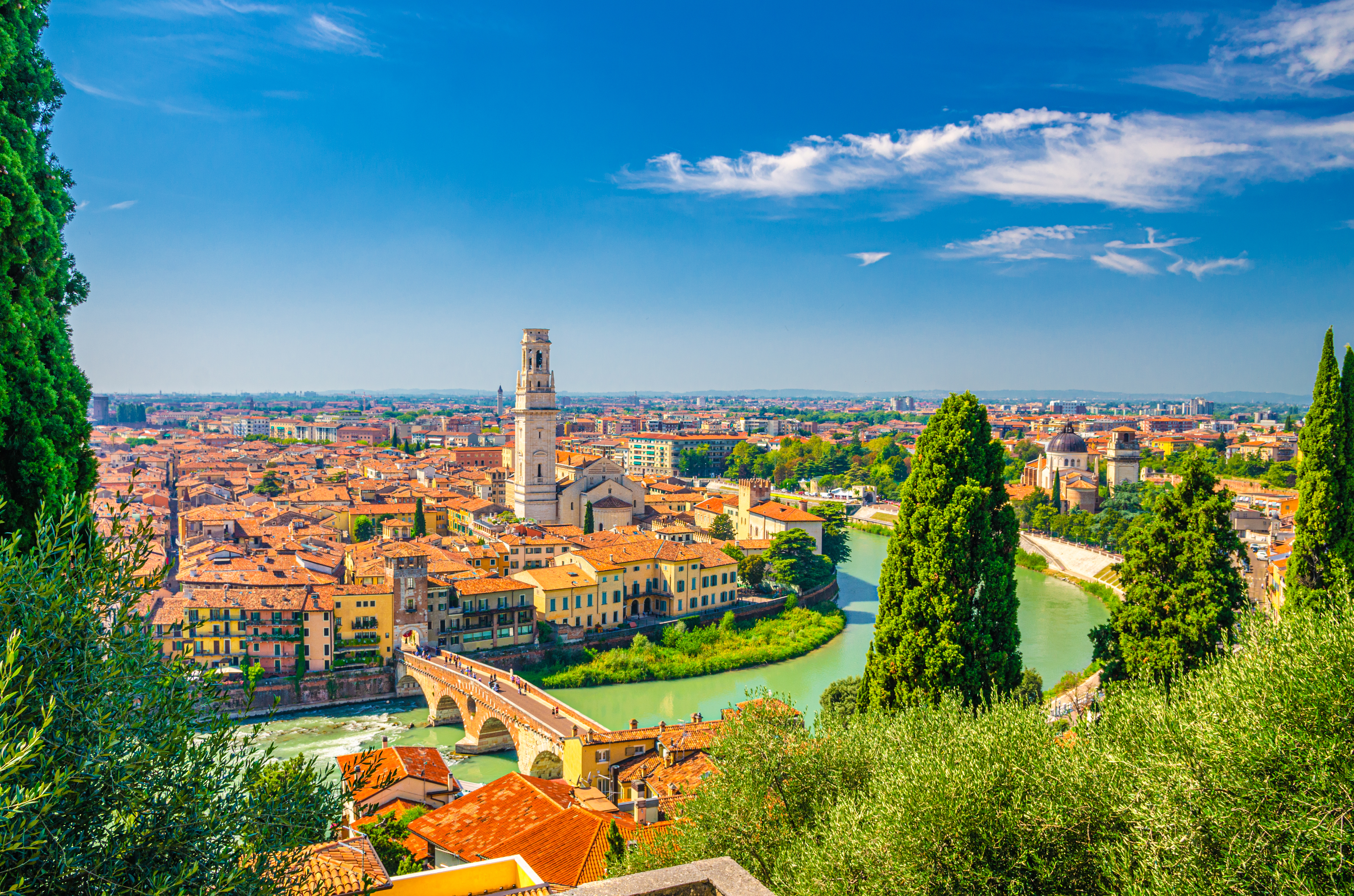Luftfoto af Veronas historiske centrum med Ponte Pietra-broen over Adige-floden og Verona-katedralen omgivet af røde tegltage i Veneto-regionen, Italien