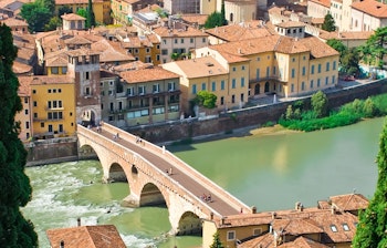 Betagende panoramaudsigt over Verona med historiske bygninger, floden Adige og middelalderarkitektur i solskin