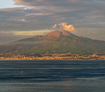 Vulkanen Vesuv i solnedgangslys med udsigt over Napoli og Middelhavet, et ikonisk italiensk landemærke