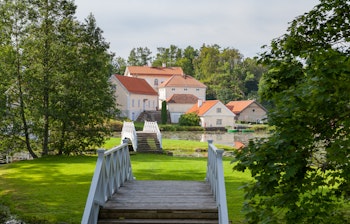 Den historiske Vihula herregård med rød tagkonstruktion spejler sig i dammen i Lahemaa Nationalpark, Estland - et idyllisk sommerlandskab