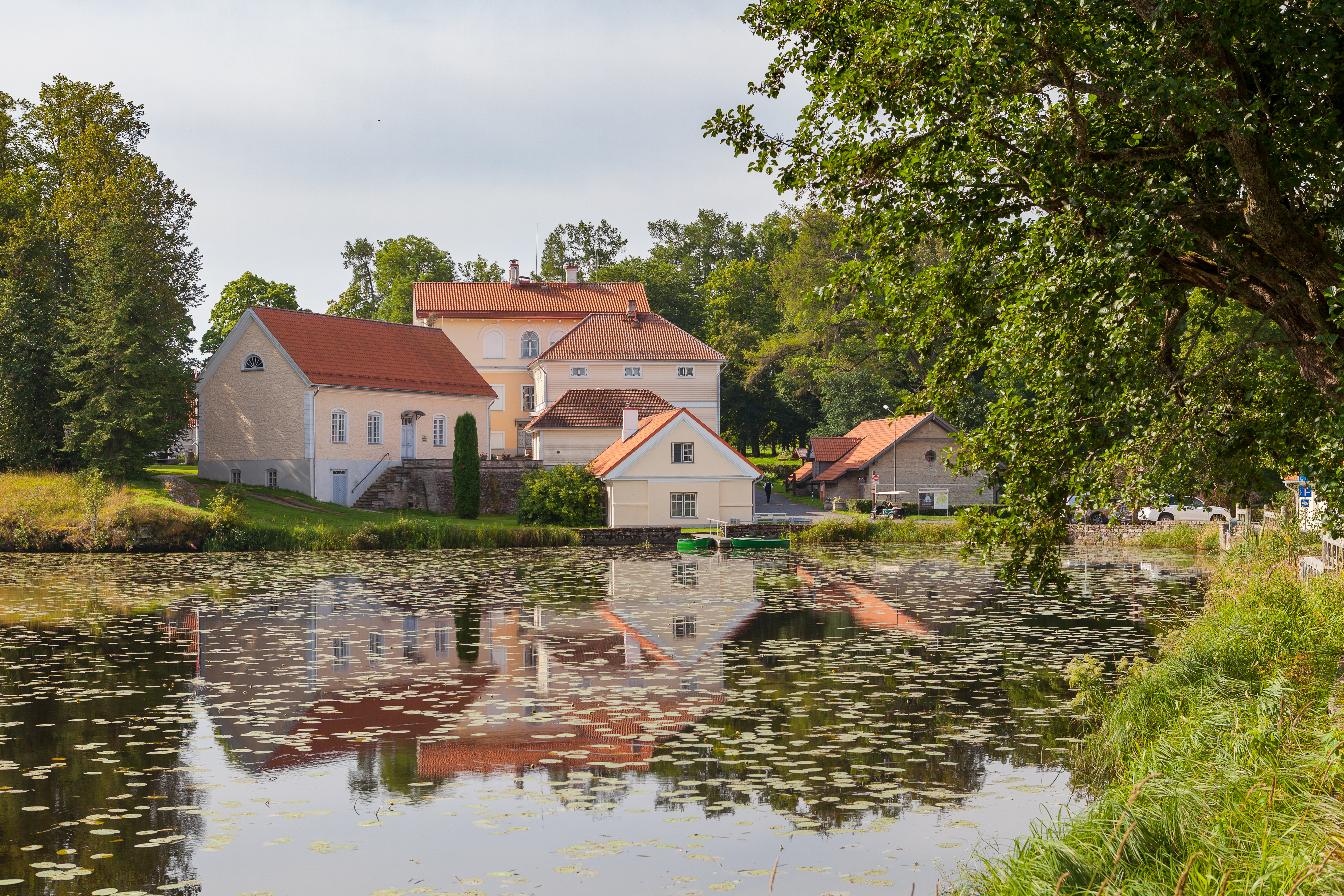 Historiske Vihula Herregård med rød tagbeklædning omgivet af en idyllisk sø og frodige haver i Lahemaa Nationalpark, Estland