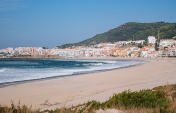 Panoramisk udsigt over den brede sandstrand i Vila Praia de Ancora med hvide bygninger og Atlanterhavets blå bølger i Portugal