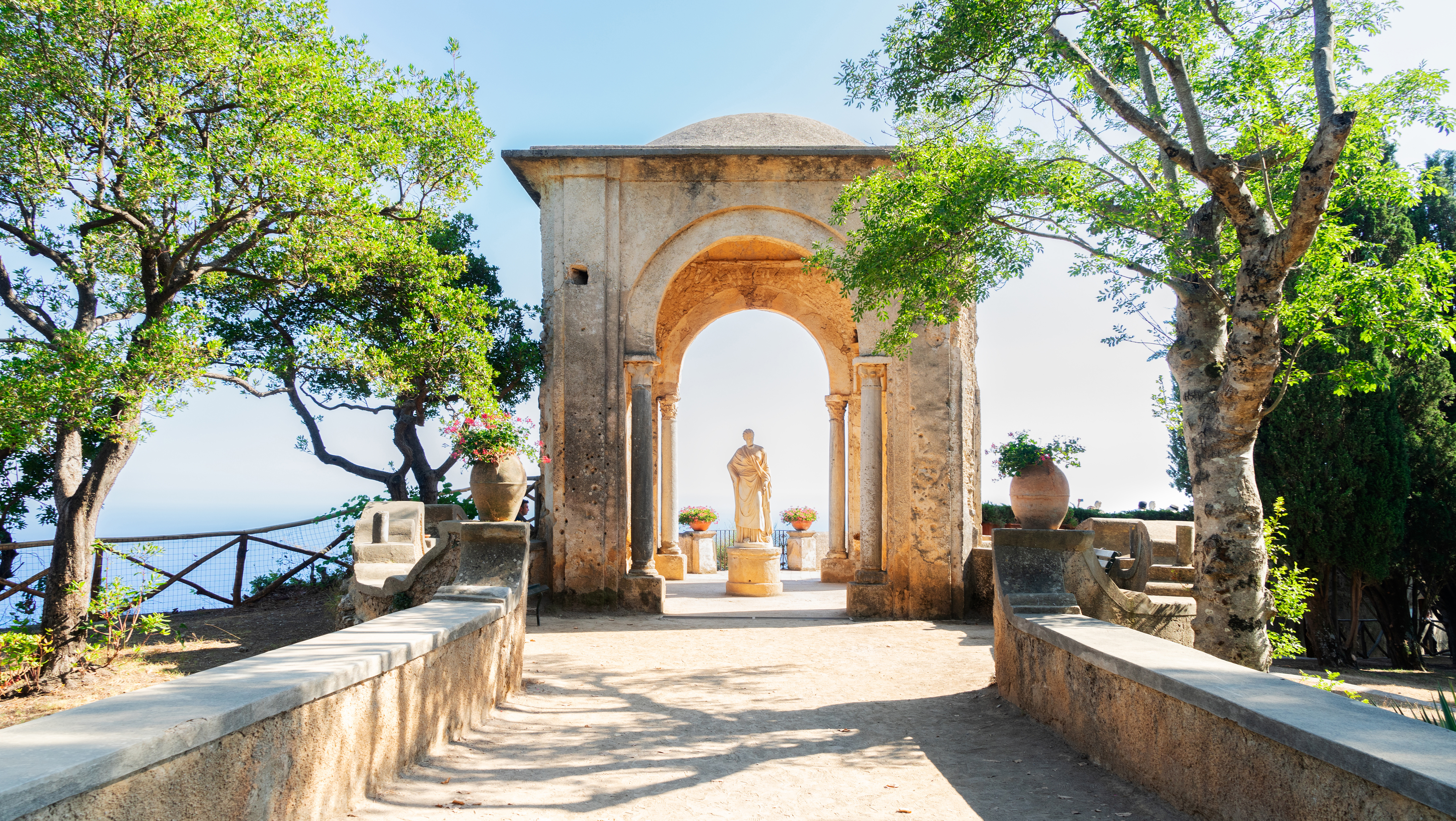Historisk stenbue og klassisk statue i haverne ved Villa Cimbrone i Ravello på Amalfikysten, Italien