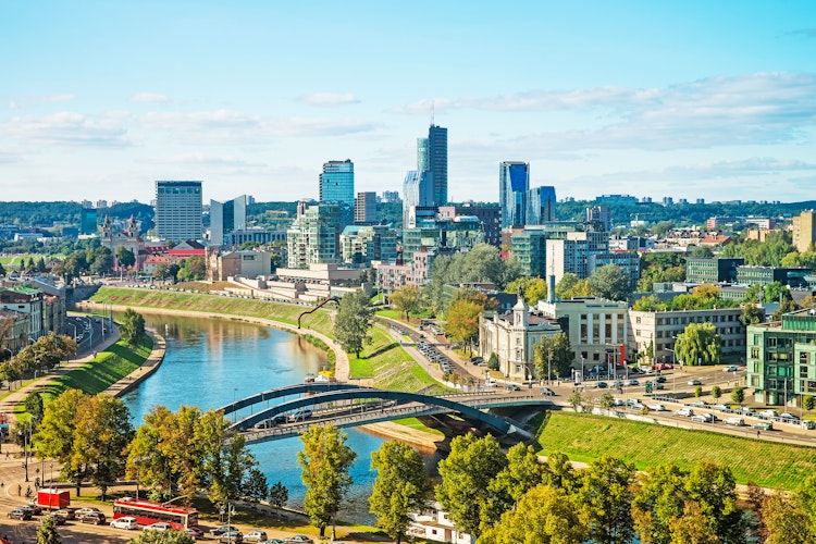 Imponerende udsigt over Vilnius' moderne finansdistrikt med skyskrabere langs Neris-floden i Litauens hovedstad