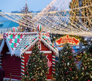 Stemningsfuld julebod på markedet i Vilnius med peberkageshus, pyntede juletræer og skilt der viser europæiske hovedstæder
