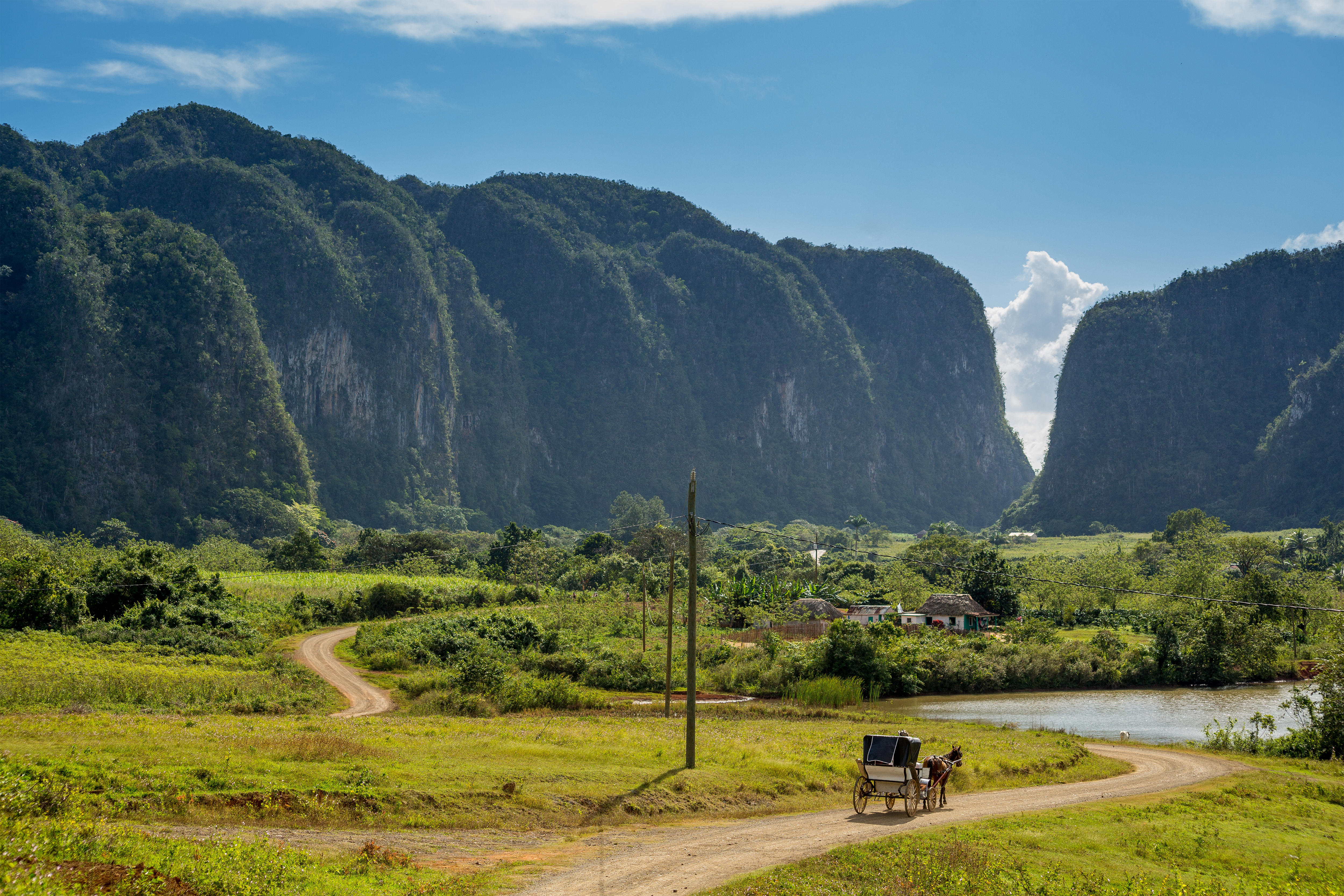 Betagende solopgang over UNESCO-verdensarvsområdet Viñales-dalen i Cuba med karakteristiske mogote-kalkstensformationer, der rejser sig fra de frodige grønne tobaksmarker indhyllet i morgentåge