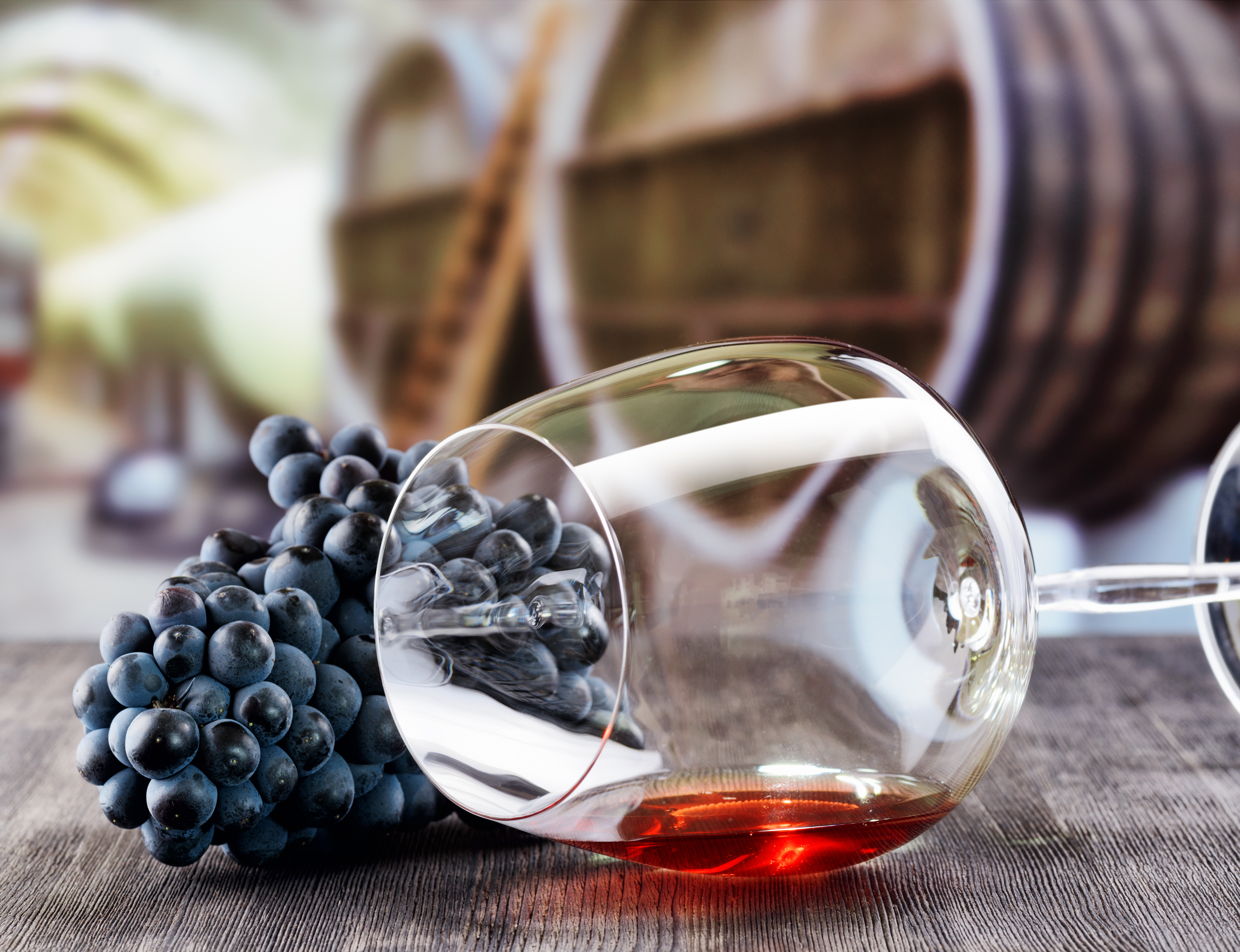 Elegant vinglas med friske druer på rustikt træbord, perfekt til vinsmagningsoplevelser på Smil Rejsers vingårdsture