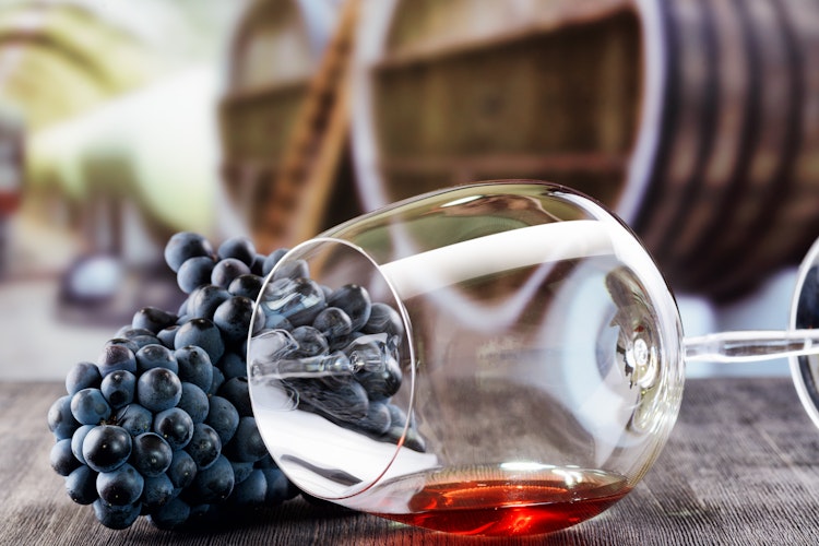 Elegant vinglas med friske druer på rustikt træbord, perfekt til vinsmagningsoplevelser på Smil Rejsers vingårdsture