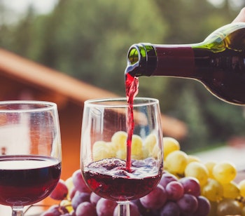 Rødvin hældes i glas ved traditionel vingård i Alto Del Chipude på La Gomera, hvor druer dyrkes i vulkansk jord