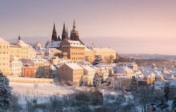 Betagende vinterpanorama over Prag Slot og Hradcany med snedækkede tage og Vltava-floden i historiske Prag