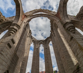Historiske ruiner af en middelalderkirke i Visby på Gotland, Sverige, med de karakteristiske høje stenmure og gotiske buer, der vidner om byens storhedstid som Østersøens handelscentrum
