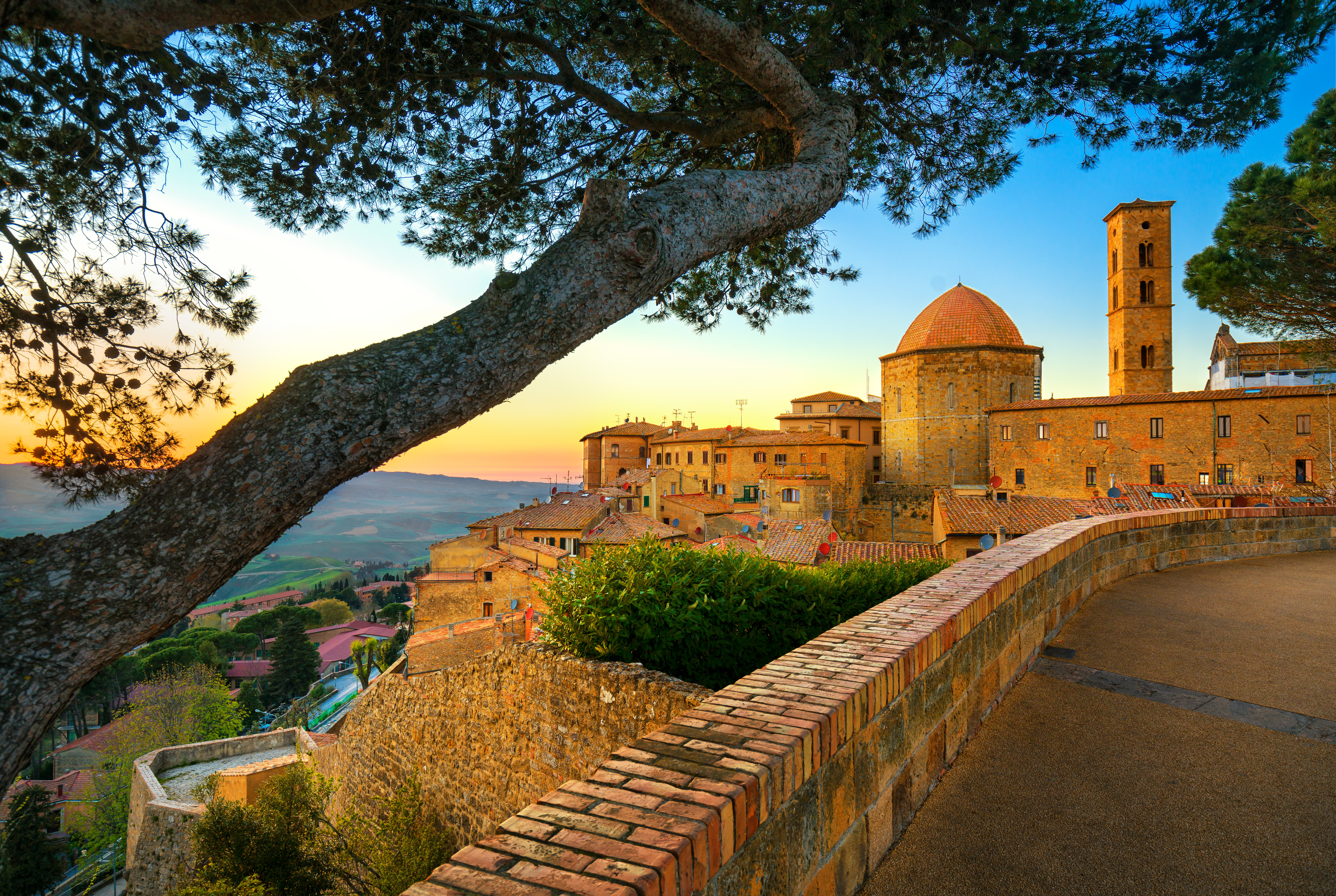 Panoramaudsigt over den middelalderlige bjergby Volterra ved solnedgang med kuppelkirke og tårn i Toscana, Italien