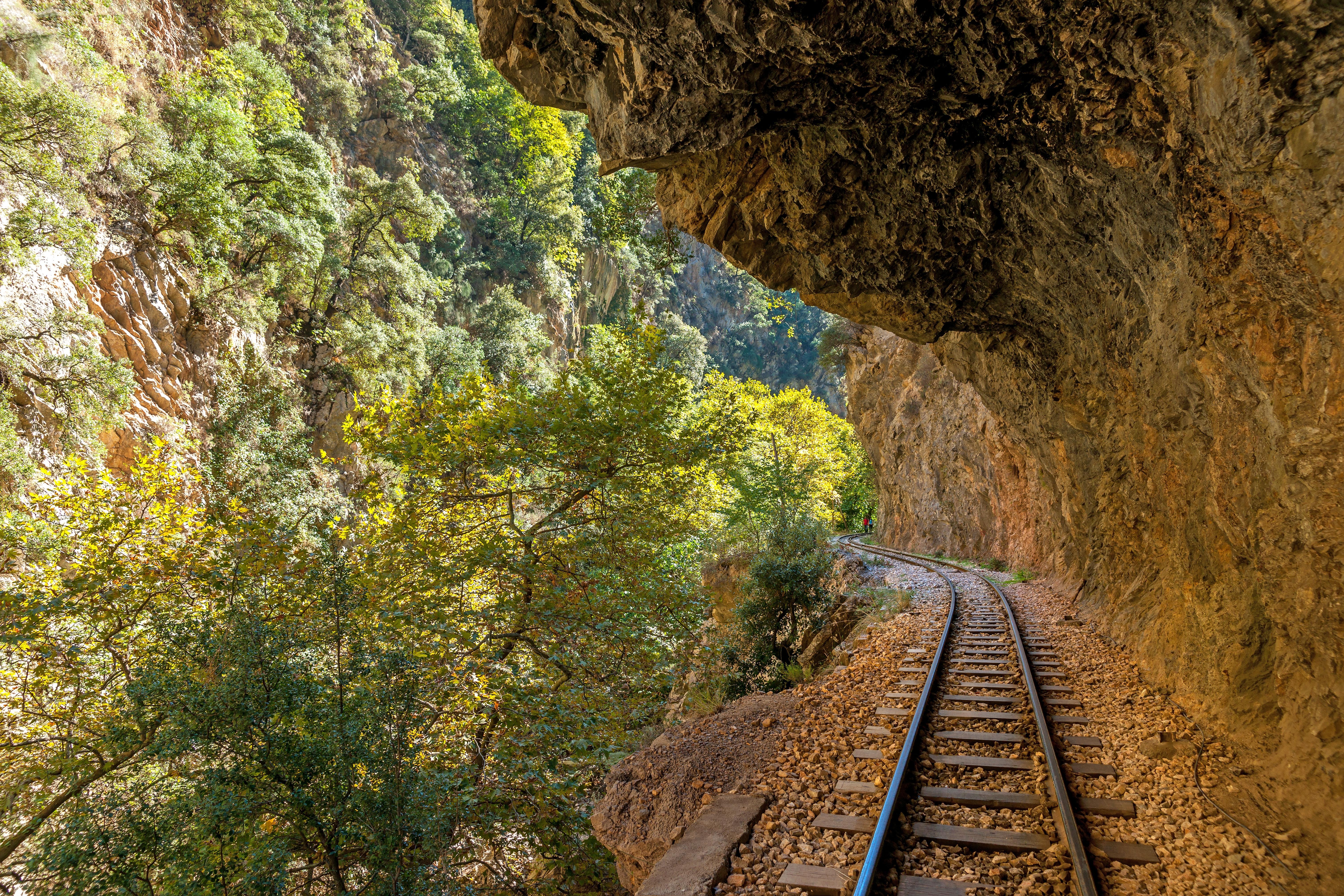 Det gamle togspor i Vouraikos Kløften mellem Kalavrita og Diakofto i Grækenland, omgivet af naturskønne landskaber.