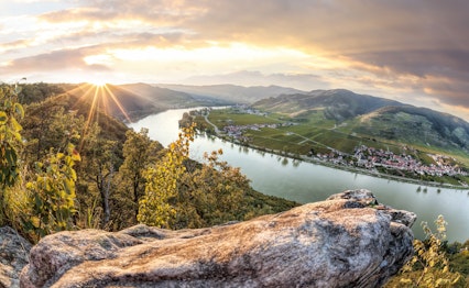 Panoramaudsigt over UNESCO-verdensarv Wachau-dalen med Donaufloden og Dürnstein landsby ved solnedgang i Østrig