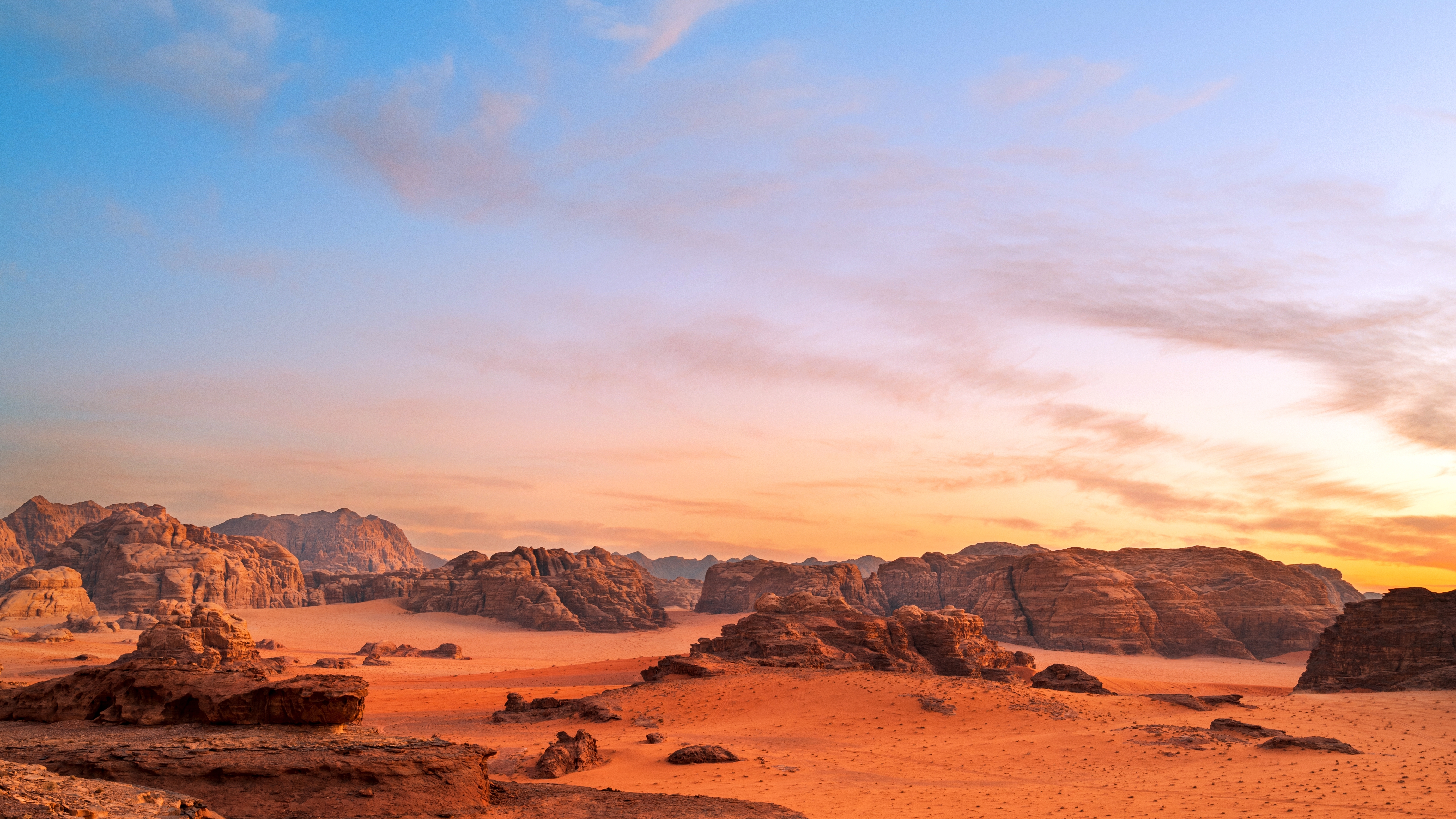 Spektakulær solnedgang over Wadi Rum ørken i Jordan med røde sandstensklipper og gyldent sand