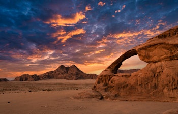 Wadi Rum ørkenbue ved solnedgang i Jordan - spektakulært ørkenlandskab