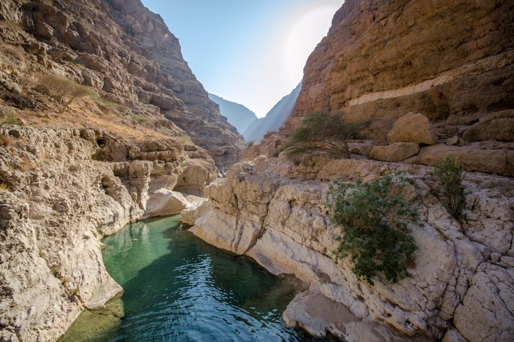 Smuk naturlig pool i Wadi Shaab kløften i Oman med krystalklart vand omgivet af dramatiske klipper, perfekt til vandreture og naturoplevelser