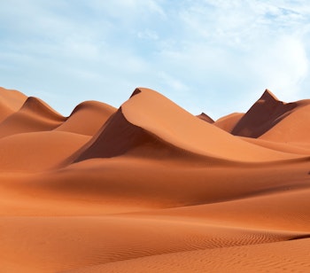 Gyldne sanddyner i Wahiba Sands ørkenen i Oman ved solnedgang, en magisk oplevelse på rundrejsen med dansktalende rejseleder