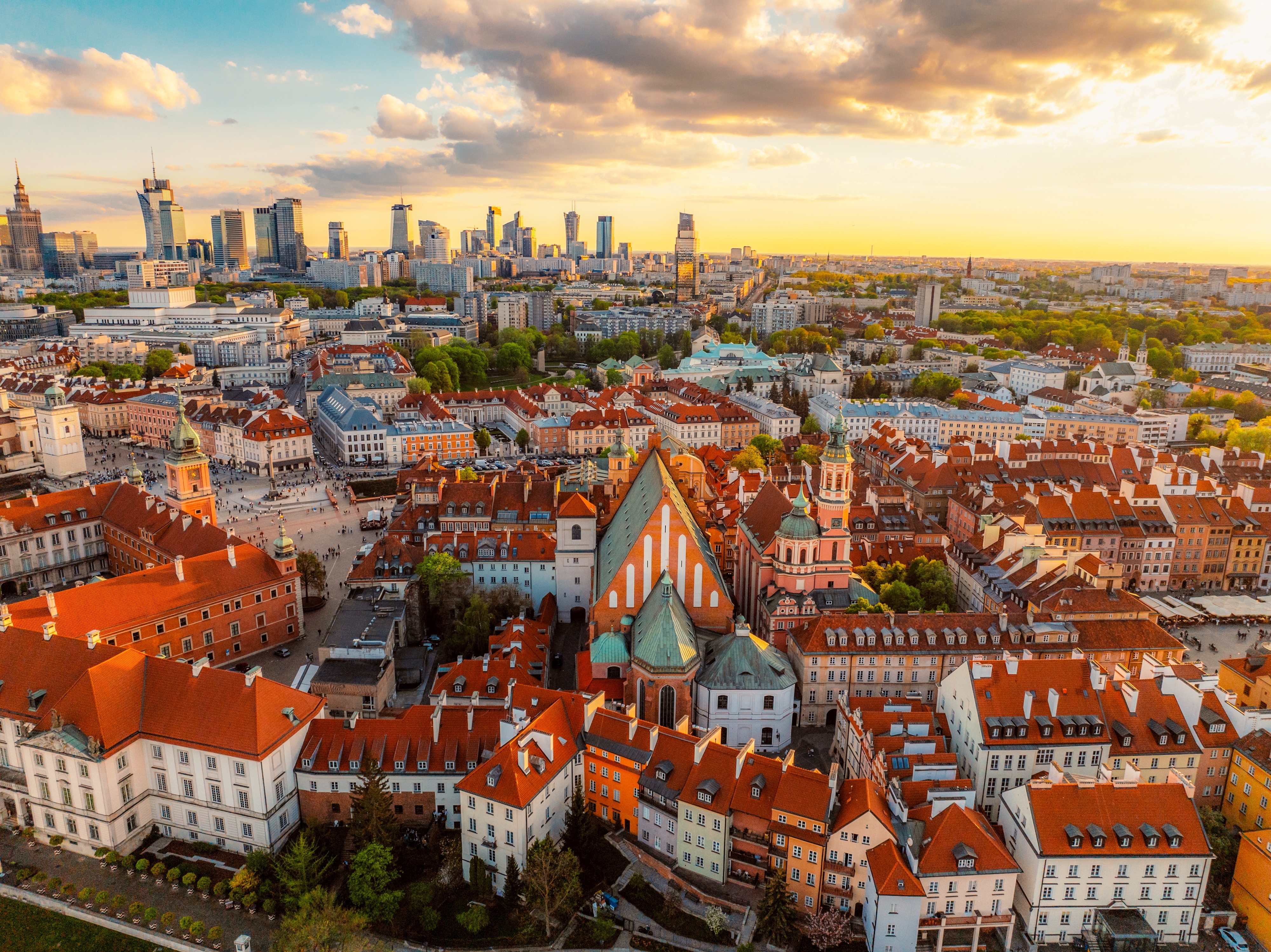 Luftfoto af Warszawas gamle bydel ved solnedgang med røde tage og moderne skyline i baggrunden, Polen