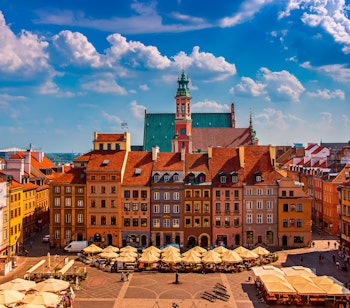Den historiske markedsplads i Warszawa med farverige barokbygninger under en skyet blå himmel - et must-see på din rejse til Polen