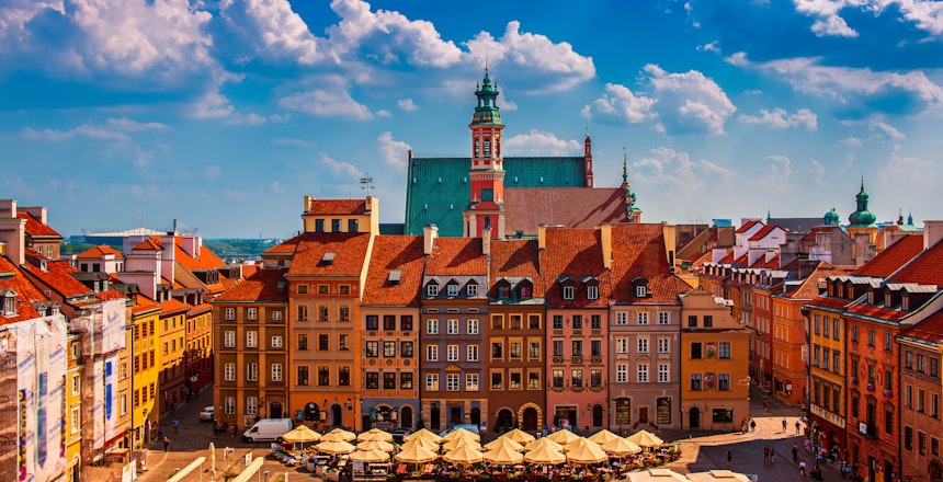 Den historiske markedsplads i Warszawa med farverige barokbygninger under en skyet blå himmel - et must-see på din rejse til Polen